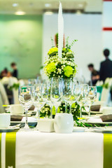 Luxury party dinner table setting with tableware and silverware and glasses set and Candlestick and flower in restaurant.