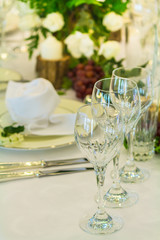 Luxury party dinner table setting with tableware and silverware and glasses set and Candlestick and flower in restaurant.