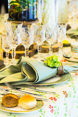 Luxury party dinner table setting with tableware and silverware and glasses set and Candlestick and flower in restaurant.