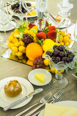 Wedding dinner table setting with tableware and silverware and glasses set and Candlestick and flower in restaurant.