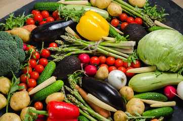 top view portrait of Assortment of fresh raw vegetables on black wooden background.