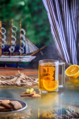 cup of tea with ship inside concept sea ill lemon ginger cookies