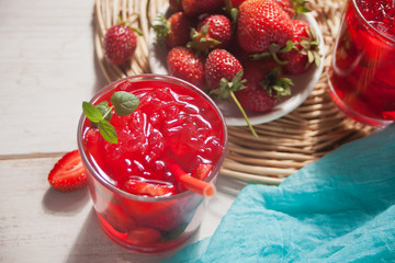 Glass with fresh homemade strawberry sweet iced tea or cocktail, lemonade with mint. Refreshing cold drink. Summer pool party. Marine theme.