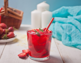 Glass with fresh homemade strawberry sweet iced tea or cocktail, lemonade with mint. Refreshing cold drink. Summer pool party. Marine theme.