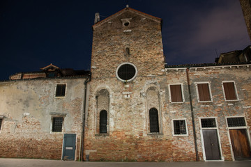 Fototapeta na wymiar Night photography of the apse of the church of San Giacomo dell'Orio in the Santa Croce district in Venice, Italy. Typical old Venetian houses.