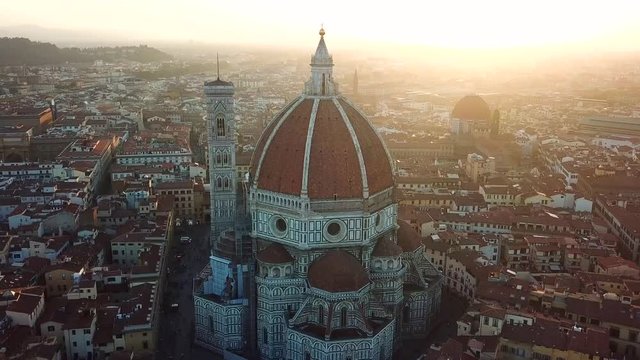 Aerial, tracking, drone shot panning around the Santa Maria del Fiore cathedral, on a sunny evening, in Florence, Toscany, Italy