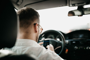 driver businessman rides a business class car through the city in sunglasses. luxury taxi services.