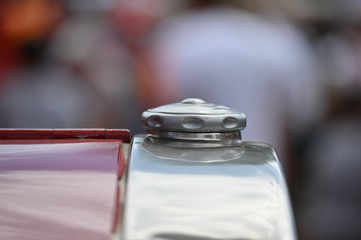 A chrome radiator cap of an old fire truck.