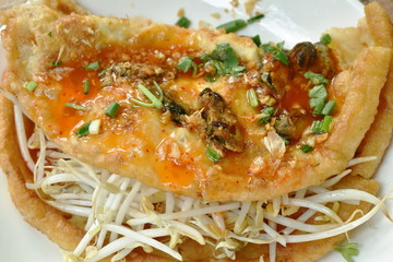 fried egg stuffed mussel with bean sprout topping garlic and dressing chili sauce on plate