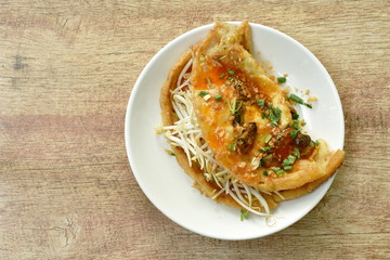 fried egg stuffed mussel with bean sprout topping garlic and dressing chili sauce on plate