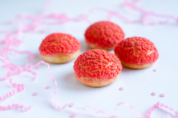 Choux Buns with Craquelin (crispy cream puffs) filled with raspberry cream on white background