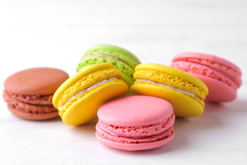 macaroons. delicious colored french macaroni cakes on a white wooden table.