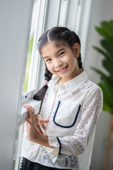 Portrait of Little Asian girl smile and happy mood in white living room