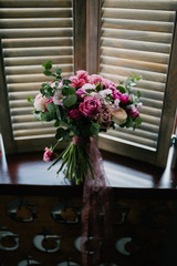 Fototapeta premium White bouquet of flowers standing in a vase on the window
