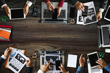 Top view of businessman Group of Multiethnic Busy People meeting with other in modern office with laptop computer, smartphone, tablet, coffee and document on table.