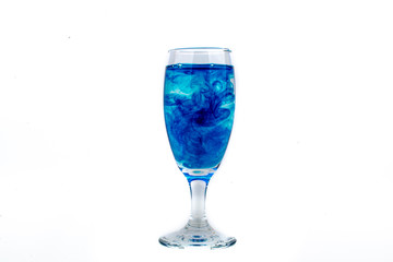Blue food coloring diffuse in water inside wine glass with empty copyspace area for slogan or advertising text message, over isolated white background.
