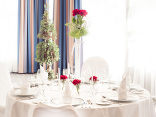 wedding table. noble wine glasses and roses decorating white clean table