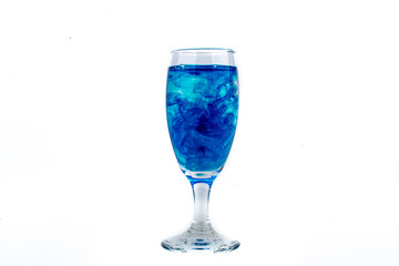 Blue food coloring diffuse in water inside wine glass with empty copyspace area for slogan or advertising text message, over isolated white background.