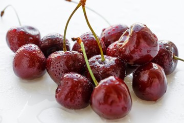 Fresh cherry berries with water drops on white background. Selective focus.