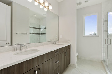 Fototapeta na wymiar bathroom with white counter tops and modern wood cabinets