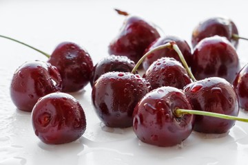 Fresh cherry berries with water drops on white background. Selective focus.