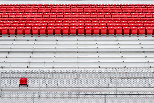 Rows of Red Seats in Empty Stadium. Concept of Emptiness. Individuality. Standing Out in the Crowd. Abstract Minimal Background.