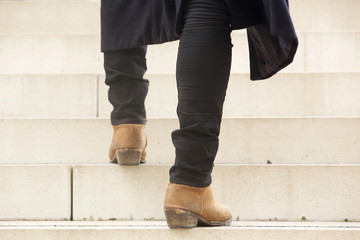 behind of man walking up stairs in boots
