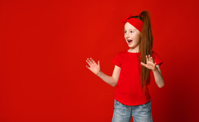 little red-haired girl with a bandage on her hair in a red t-shirt happily shouts when she sees something to the side