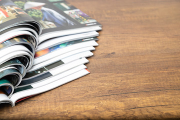 Selective focus of the stacking magazine place on wooden table and copy space.
