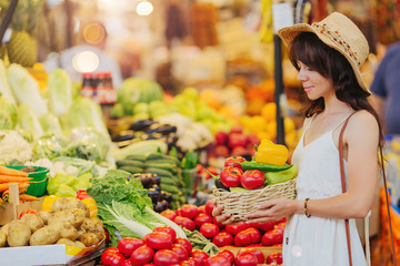 Woman is chooses  fruits and vegetables at food market.