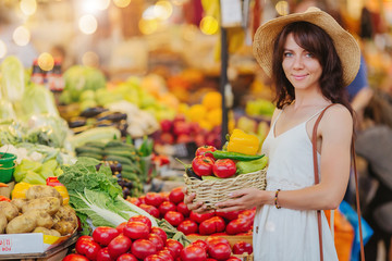 Woman is chooses  fruits and vegetables at food market.