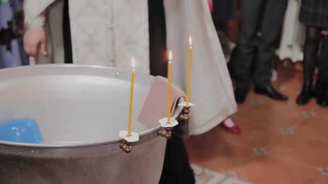 Fonts for the baptism of babies with burning candles in the Orthodox Church.