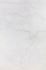 White wall with cracked plaster as abstract background