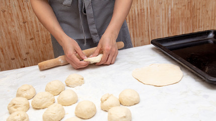 Girl rolls the dough in the kitchen