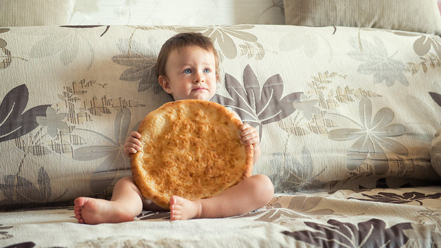 boy with uzbek cake on the couch at home