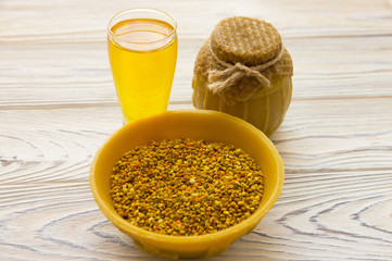 Honey jar and bee pollen on the wooden background