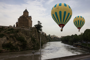 Fototapeta na wymiar Tbilisi, Georgia. Kura river embankment and hot air balloons.
