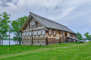 Obraz premium Scenic view of small wooden house on Kizhi island on Onezhsky lake in Russian Federation. Beautiful summer sunny look of traditional building of russian North in Karelia