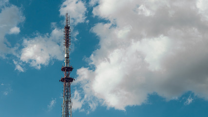 Obraz premium telecommunication radio tower on the vast blue sky background. White clouds on sky.