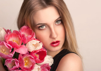 Obraz na płótnie Canvas blonde face, gray eyes, tulips flowers