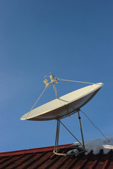 Satellite dish on the roof of a house in winter.