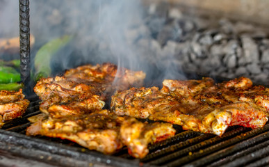 Tasty chicken meat on the grill with fire flames