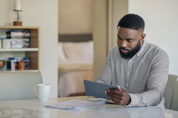 African American man doing his online banking with a tablet