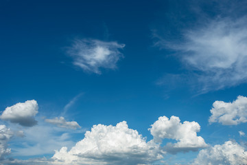 Blue sky background with green fields and white clouds.