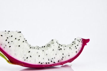Close up the dragon fruit that is bitten on white background. Dragon fruit is popular as a fresh fruit.Is a mixture of fruit salad or blended into juice.