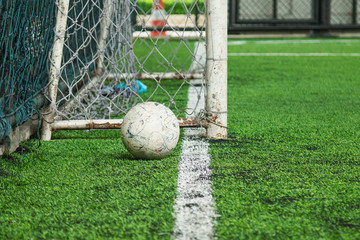 Old soccer ball on field