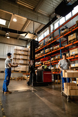 Small group of manual workers working in a warehouse.