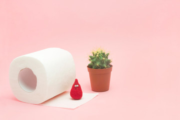 Hemorrhoid, constipation treatment health problems. Toilet paper, a cactus and crochet blood drop on the pink background. Hemorrhoid problems. - 275507502