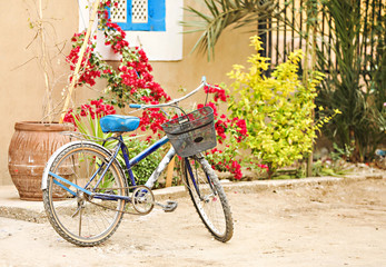 Fototapeta na wymiar An old bike sitting on a dirt road with colorful background. 