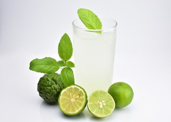 Bergamot , sweet basil and lime mixed with soda in a glass and sweet basil leaves placed on the glass.